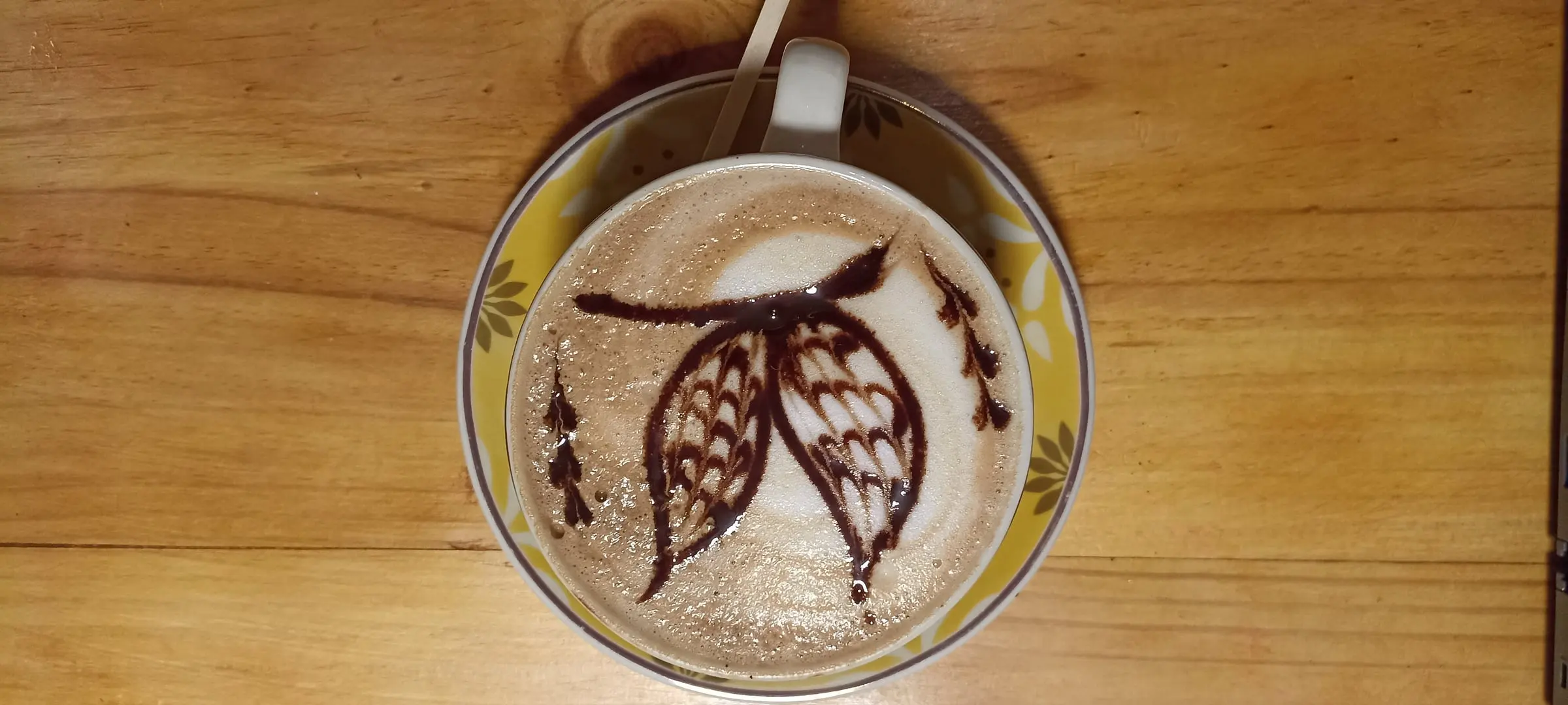 Capuchino decorado con un dibujo de mazorca de cacao en Café EKA
